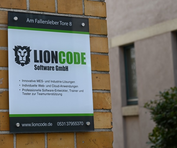 An eine Hauswand geschraubtes Firmenschild der Lioncode Software GmbH